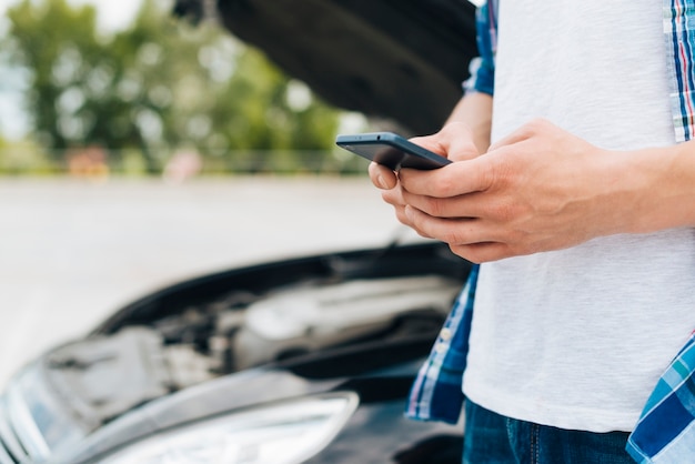 Plano medio del hombre revisando el teléfono