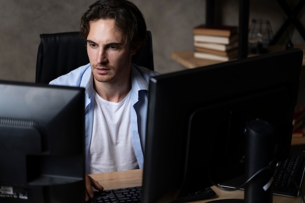 Plano medio hombre sentado en el escritorio