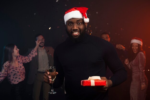 Plano medio del hombre sonriente bebiendo champán en la fiesta de año nuevo