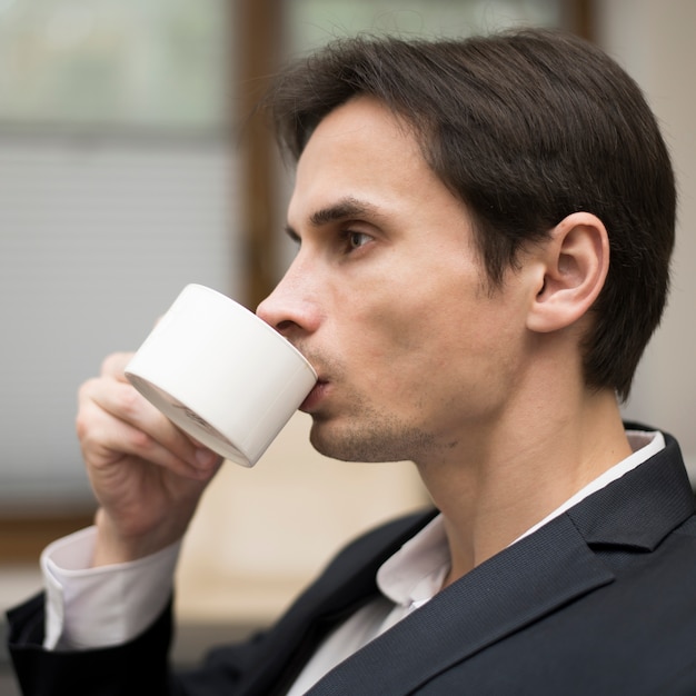 Plano medio del hombre tomando café