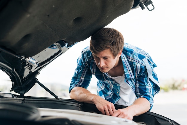 Plano medio del hombre trabajando en el motor