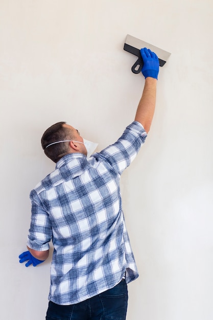 Plano medio de un hombre trabajando en una pared