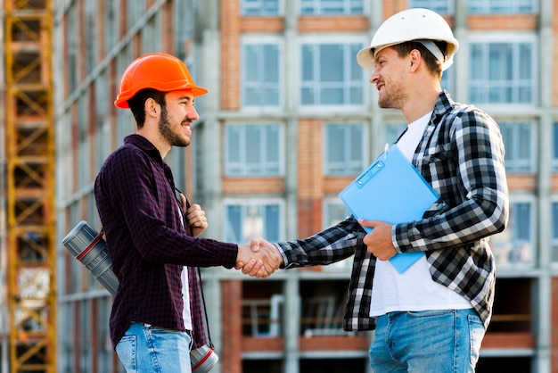 Foto gratuita plano medio del ingeniero y arquitecto dándose la mano.