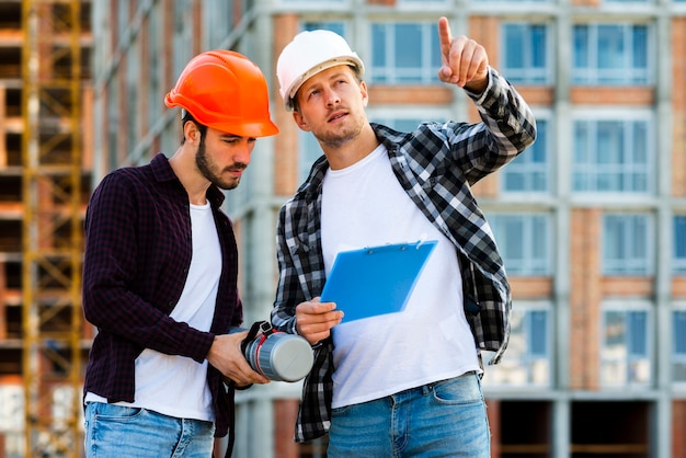 Plano medio de ingeniero y arquitecto mirando portapapeles