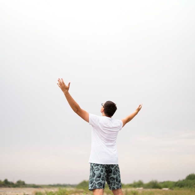 Foto gratuita plano medio de un joven mirando al cielo