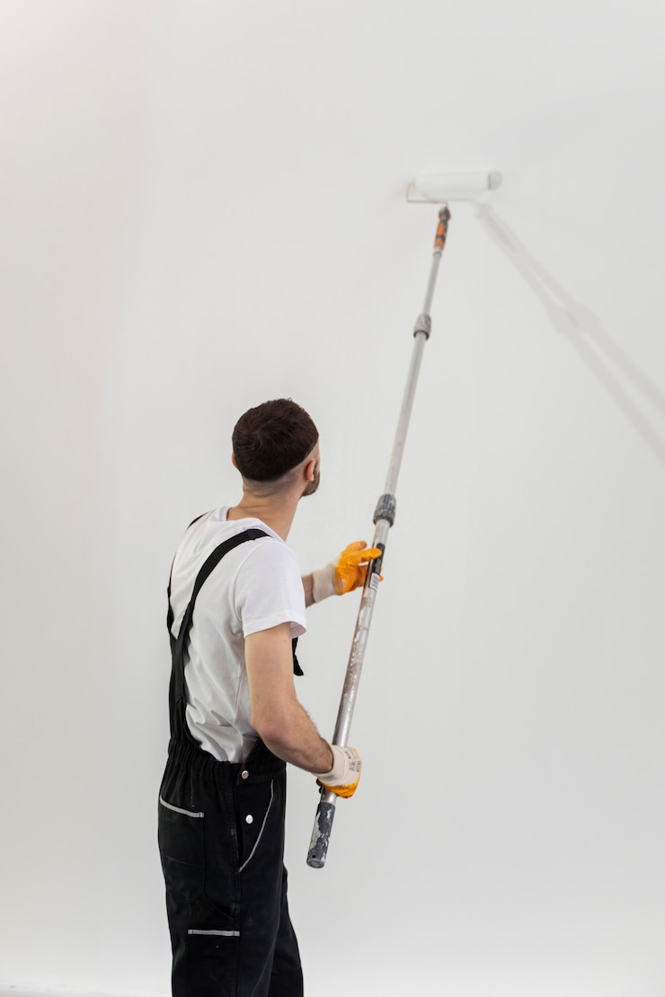 Foto gratuito plano medio joven pintando pared