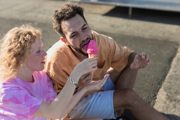 Plano medio linda pareja con helado de rosa