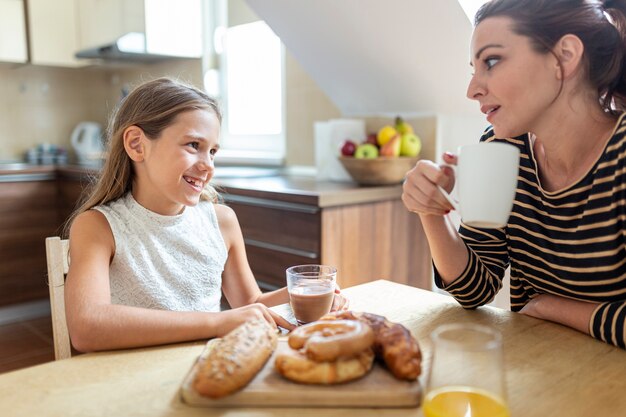 Plano medio de madre e hija en la cocina