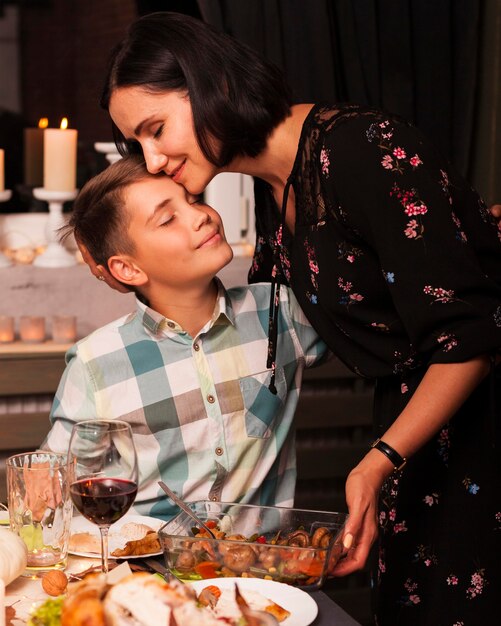 Plano medio, madre e hijo en la mesa de la cena