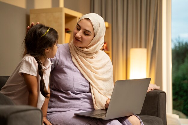 Plano medio madre y niña con laptop