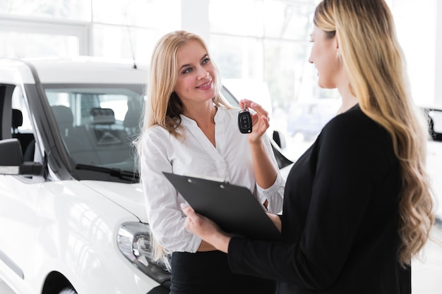 Plano medio de mujer comprando auto nuevo