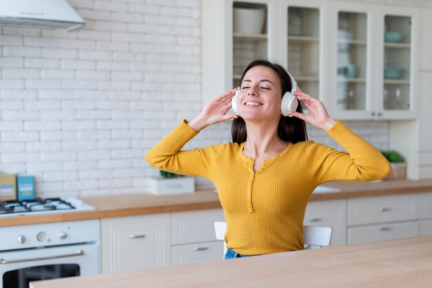 Plano medio de mujer disfrutando de la música.