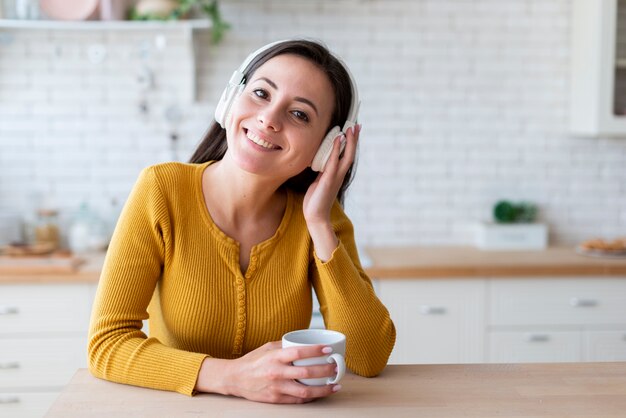 Plano medio de mujer escuchando música.