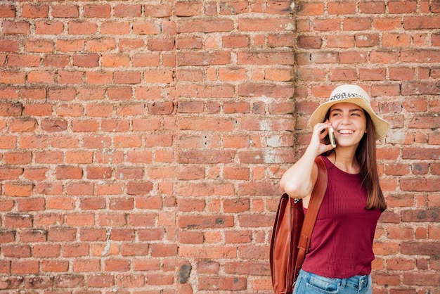 Plano medio de mujer con fondo de pared de ladrillo