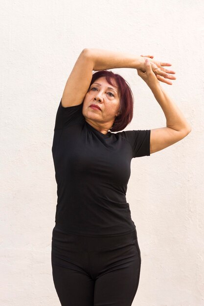 Plano medio de mujer haciendo ejercicio de calentamiento