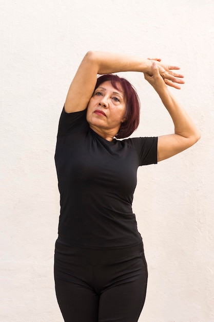 Plano medio de mujer haciendo ejercicio de calentamiento