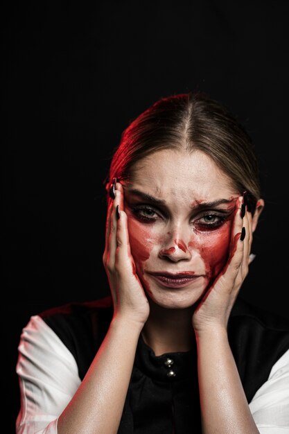 Plano medio de mujer con maquillaje ensangrentado