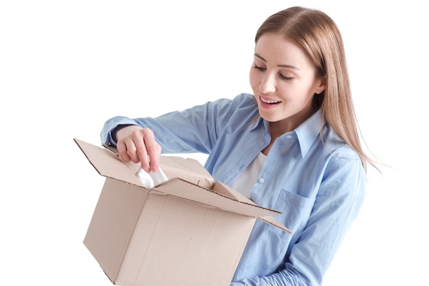 Plano medio de una mujer mirando dentro de un paquete de entrega