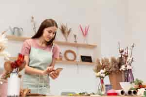 Foto gratuita plano medio de mujer de negocios usando su teléfono móvil