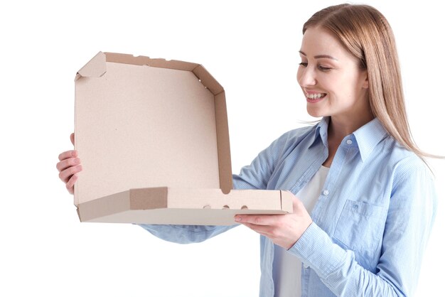 Plano medio de mujer sonriente mirando en una caja de pizza