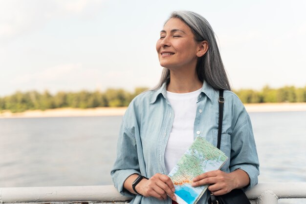 Plano medio, mujer sonriente, tenencia, mapa