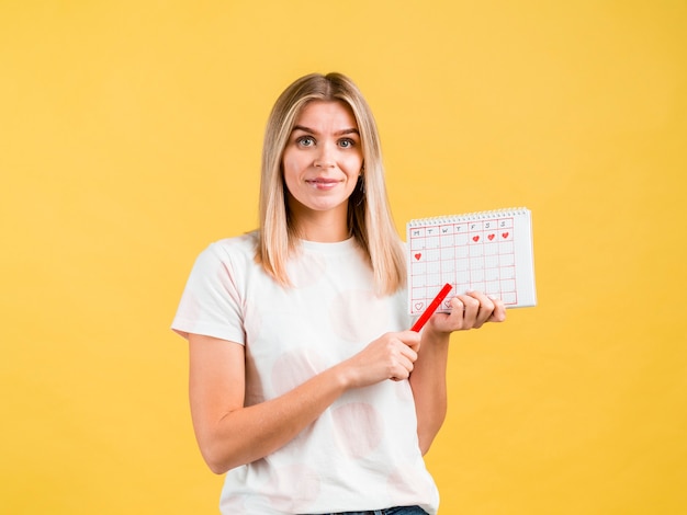 Plano medio de mujer sosteniendo una pluma y calendario de época