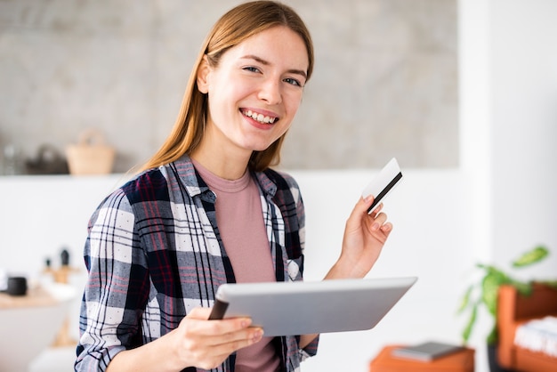 Plano medio de mujer sosteniendo su tarjeta de crédito