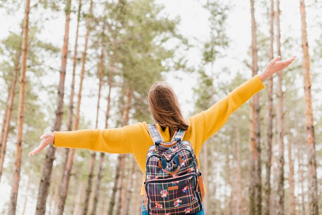 Plano medio de una mujer viajera en el bosque.