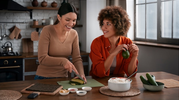 Plano medio mujeres aprendiendo a hacer sushi.