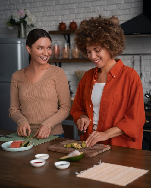 Plano medio mujeres aprendiendo a hacer sushi.