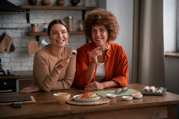 Plano medio mujeres aprendiendo a hacer sushi.