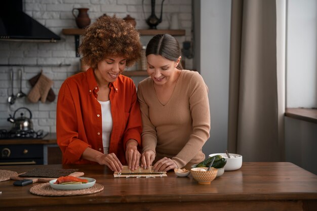 Plano medio mujeres aprendiendo a hacer sushi.