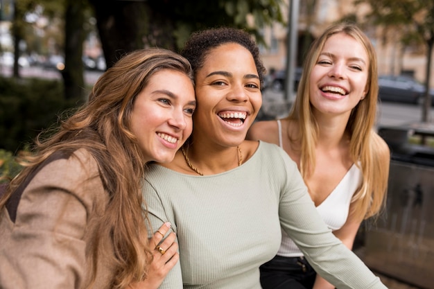 Plano medio de mujeres riendo tomando un selfie