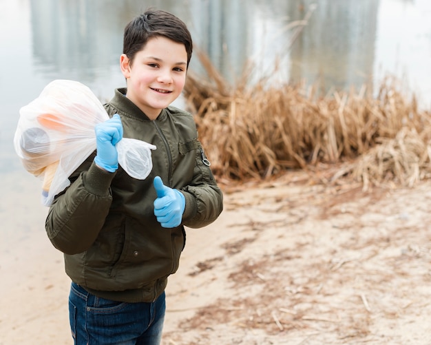 Foto gratuita plano medio de niño con bolsa de plástico