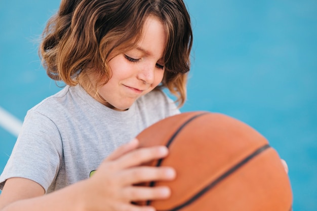 Foto gratuita plano medio de un niño jugando baloncesto