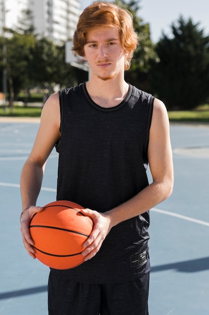 Plano medio de niño con pelota de baloncesto