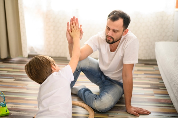 Plano medio padre e hijo choca esos cinco