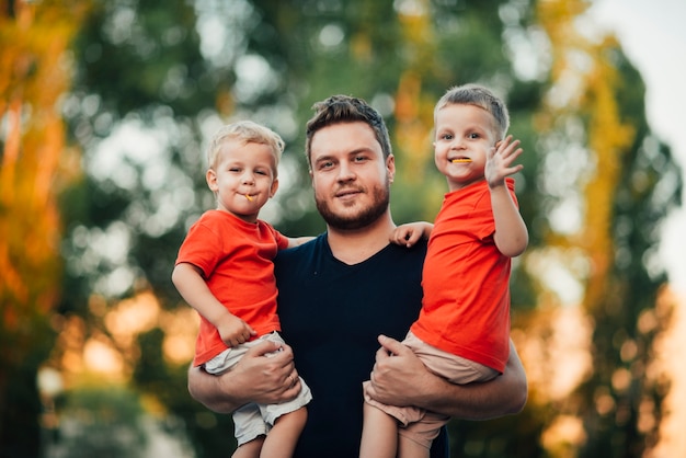 Plano medio padre e hijos mirando a cámara