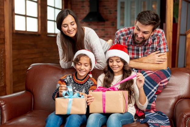 Foto gratuita plano medio padres felices mirando niños