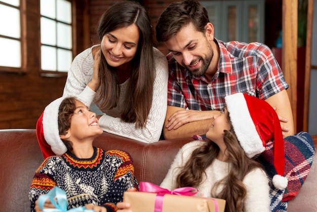 Foto gratuita plano medio padres felices mirando a sus hijos