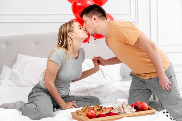 Plano medio pareja besándose en el día de san valentín