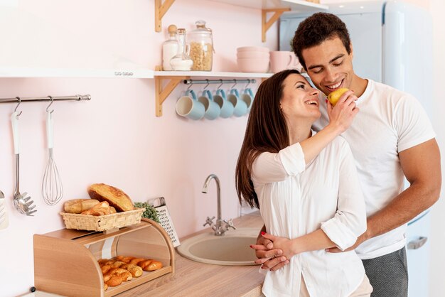 Plano medio pareja cogidos de la mano en la cocina