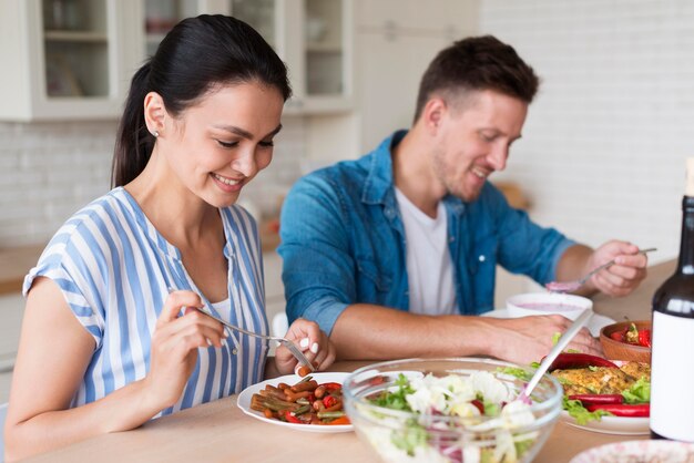 Plano medio pareja comiendo juntos