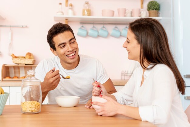 Plano medio pareja desayunando juntos