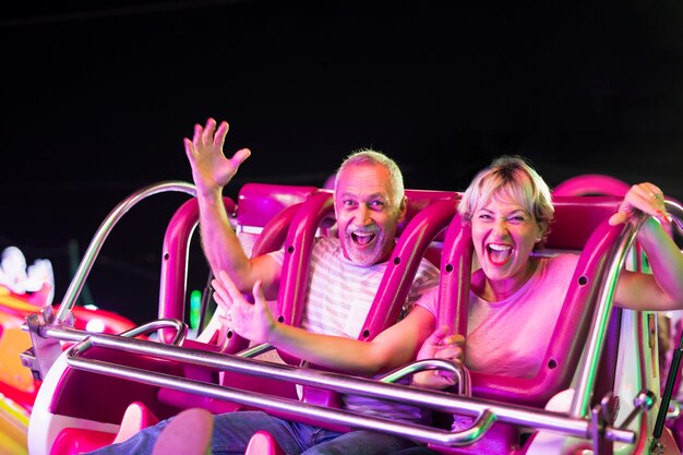 Plano medio pareja feliz en atracción de feria