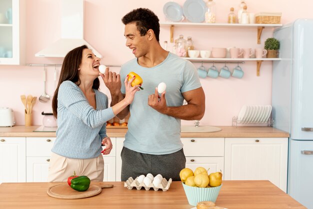 Plano medio pareja feliz cocinando juntos