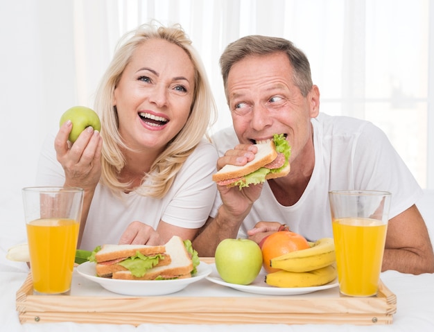 Plano medio pareja feliz comiendo sano juntos