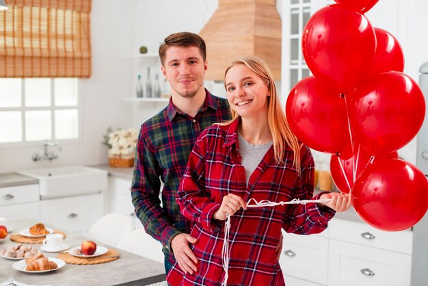 Plano medio pareja feliz con globos