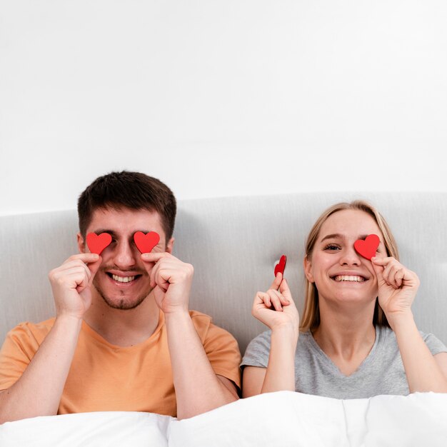 Plano medio pareja feliz con papel en forma de corazón