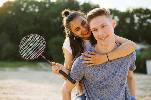 Plano medio pareja feliz con raqueta de bádminton